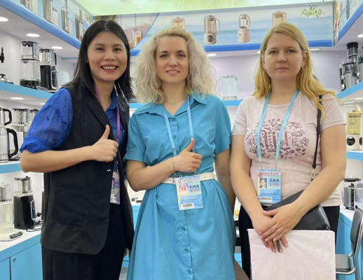 Foto de grupo del equipo de Zhongshan Yuekon Electrical Appliances Co., Limited con clientes internacionales durante una reunión de negocios, mostrando asociación y colaboración.