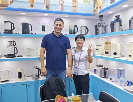 Imagen de miembros del equipo de Zhongshan Yuekon Electrical Appliances Co., Limited y clientes internacionales sonriendo para una foto grupal, lo que refleja una interacción comercial positiva.